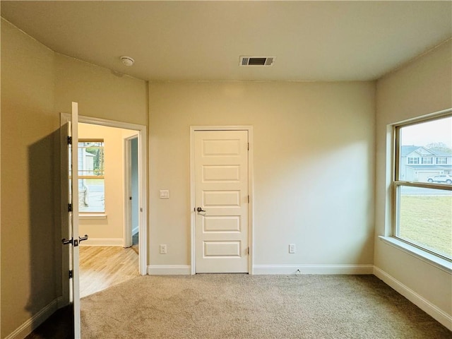 spare room featuring light carpet and a healthy amount of sunlight