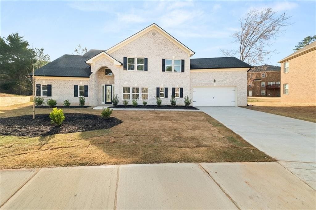 4647 Lantern Ct, Stonecrest, GA 30038 - view of front of property featuring driveway, an attached garage, brick siding, and a front lawn