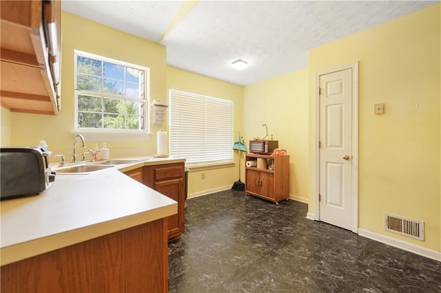 3620 Darwin Pl, Duluth, GA 30096 - kitchen featuring light countertops, brown cabinets, and a textured ceiling