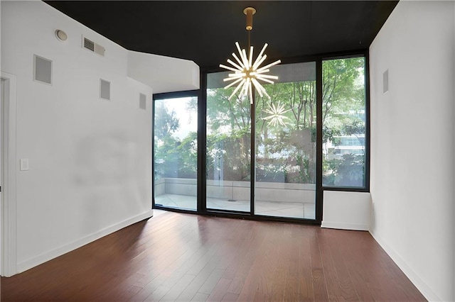 855 Peachtree St NE Unit 1108, Atlanta, GA 30308 - spare room with expansive windows, plenty of natural light, a chandelier, and wood finished floors