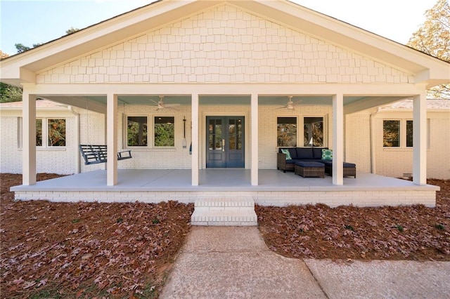 rear view of house featuring ceiling fan, an outdoor living space, and french doors