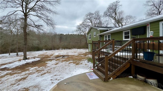 yard covered in snow featuring a wooden deck