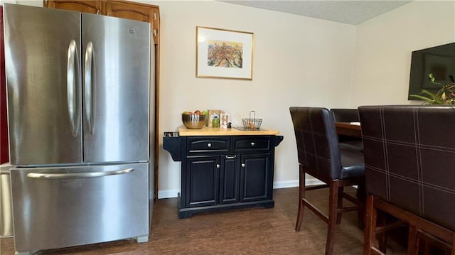 interior space with stainless steel fridge and dark hardwood / wood-style flooring