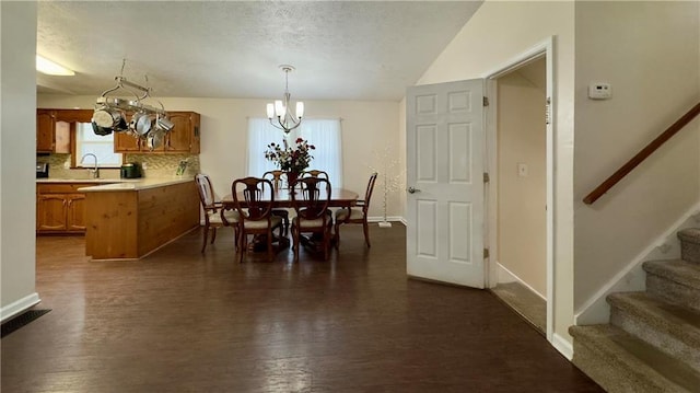 dining area featuring dark hardwood / wood-style floors and an inviting chandelier