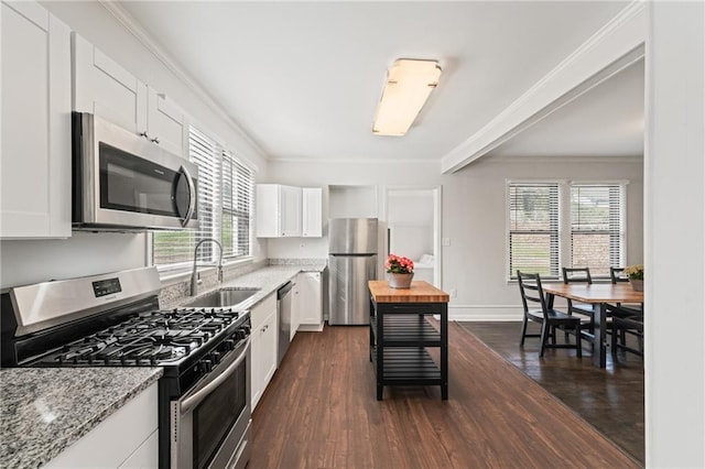 kitchen featuring dark hardwood / wood-style flooring, stainless steel appliances, white cabinets, and light stone counters