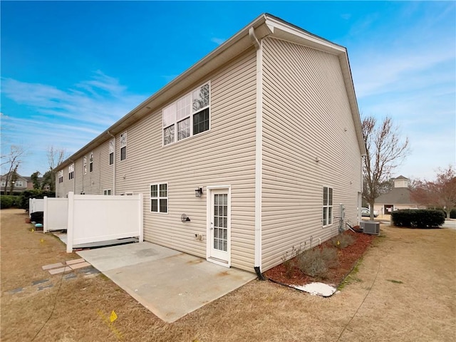 rear view of house featuring a patio, cooling unit, and fence