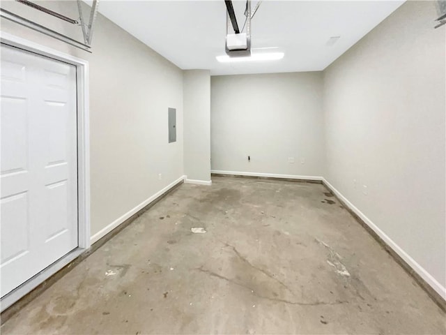 garage with electric panel, a garage door opener, and baseboards