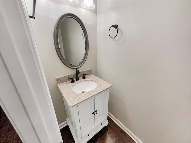 bathroom featuring vanity, baseboards, and wood finished floors