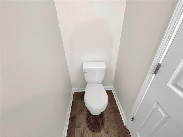 bathroom featuring baseboards, toilet, and wood finished floors