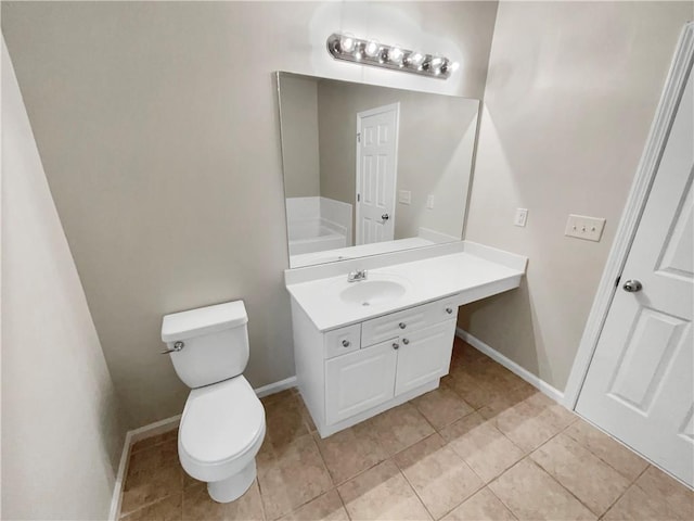 bathroom with tile patterned flooring, toilet, vanity, and baseboards