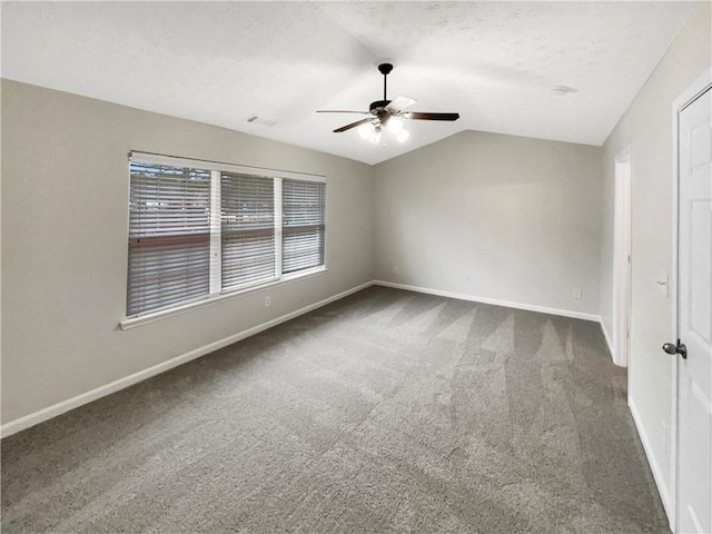 interior space with ceiling fan, baseboards, carpet, vaulted ceiling, and a textured ceiling