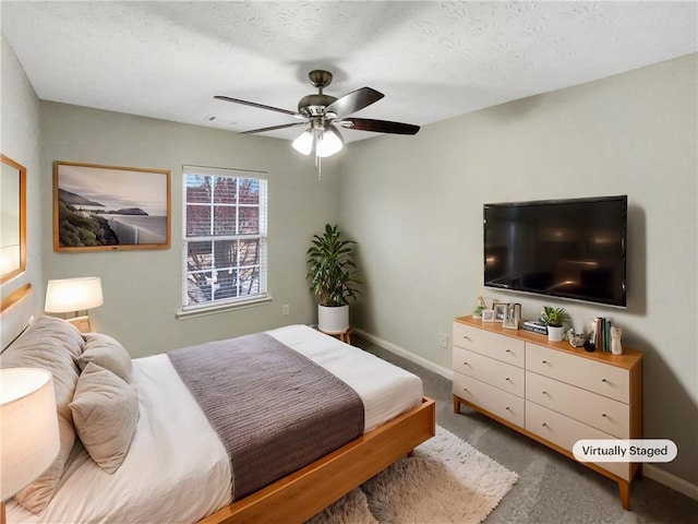 bedroom featuring carpet, baseboards, and a textured ceiling