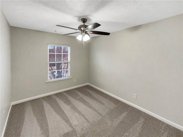 carpeted spare room with a textured ceiling, baseboards, and ceiling fan