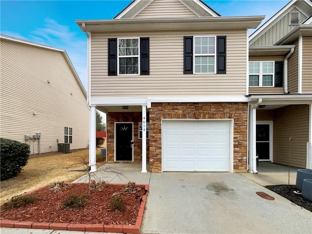 view of front facade featuring driveway, central air condition unit, a garage, and stone siding