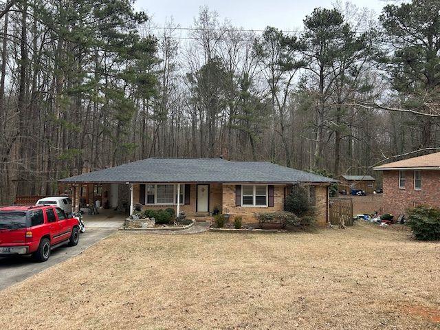 single story home featuring a carport and a front lawn