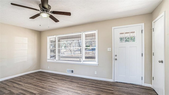 entryway featuring dark hardwood / wood-style flooring, a textured ceiling, and ceiling fan