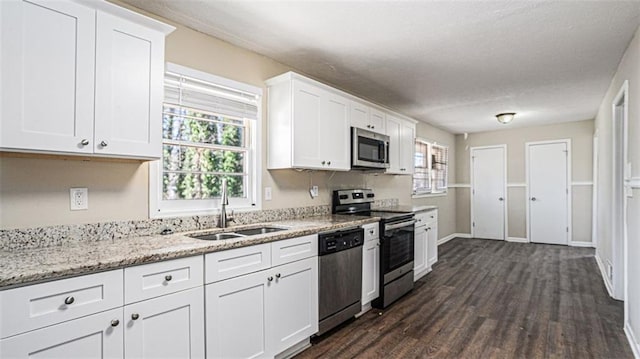 kitchen with plenty of natural light, white cabinets, appliances with stainless steel finishes, and sink