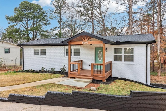 ranch-style home featuring a front yard, fence, and brick siding