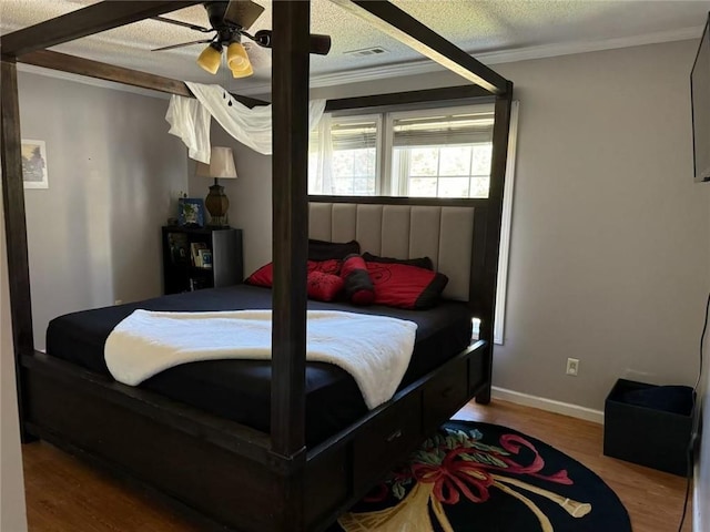 bedroom with ceiling fan, ornamental molding, a textured ceiling, and wood-type flooring