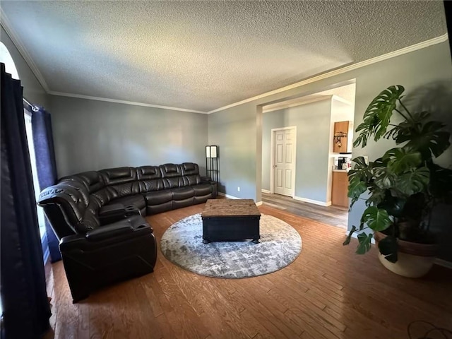 living room with hardwood / wood-style floors, a textured ceiling, and ornamental molding