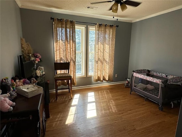 bedroom featuring ornamental molding, multiple windows, hardwood / wood-style flooring, and ceiling fan