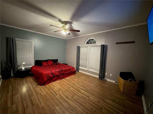 bedroom with ceiling fan, ornamental molding, and wood-type flooring