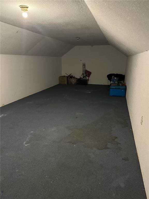 bonus room featuring a textured ceiling and vaulted ceiling