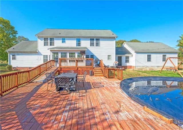 rear view of property featuring a wooden deck