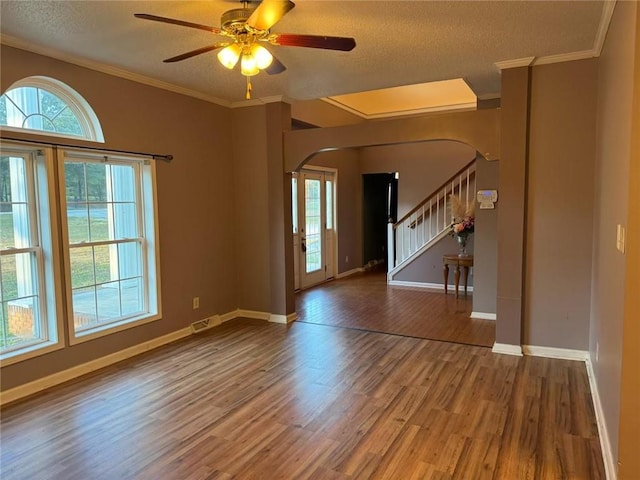 unfurnished room with a textured ceiling, wood-type flooring, ceiling fan, and crown molding