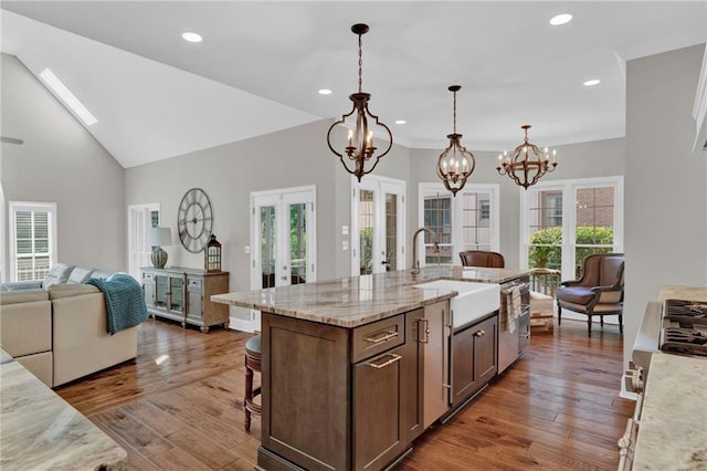 1313 Fallsbrook Ter NW, Acworth, GA 30101 - kitchen featuring french doors, a chandelier, open floor plan, a kitchen bar, and dark wood-style floors