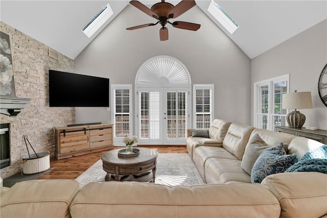 1313 Fallsbrook Ter NW, Acworth, GA 30101 - living area featuring a skylight, high vaulted ceiling, wood finished floors, a ceiling fan, and french doors