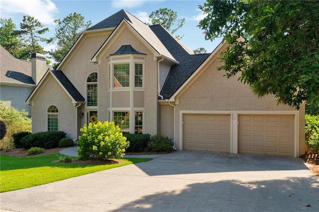 1313 Fallsbrook Ter NW, Acworth, GA 30101 - view of front of house with stucco siding, an attached garage, driveway, a chimney, and roof with shingles