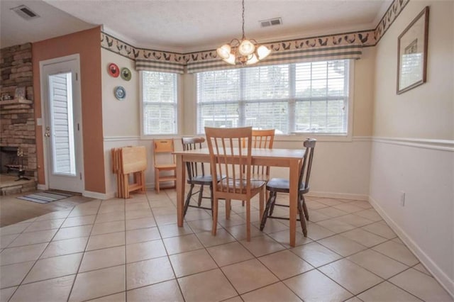 tiled dining area with a chandelier and a healthy amount of sunlight