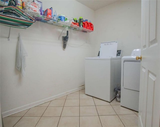 laundry area with washer and dryer and light tile patterned floors