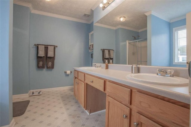 bathroom with a shower with door, vanity, a textured ceiling, and crown molding