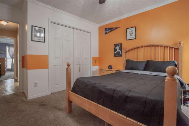 carpeted bedroom featuring ceiling fan, crown molding, and a closet