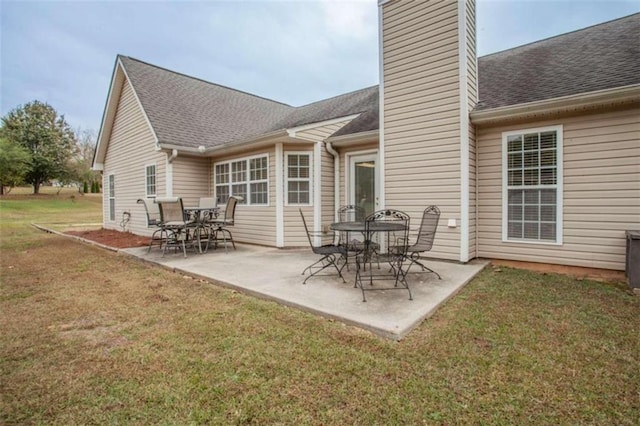 rear view of house featuring a lawn and a patio