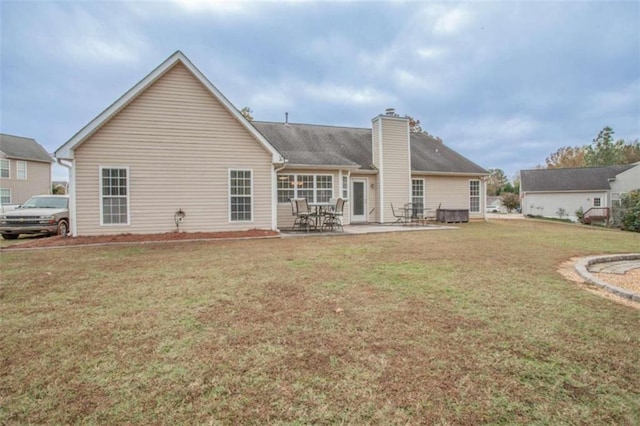 rear view of property featuring a patio area and a lawn