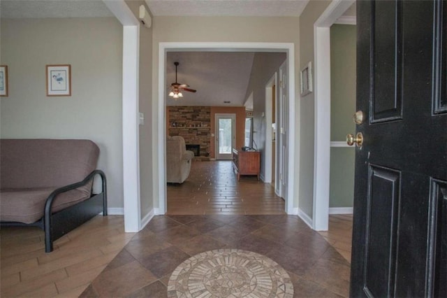 foyer entrance featuring a fireplace, dark hardwood / wood-style floors, and ceiling fan