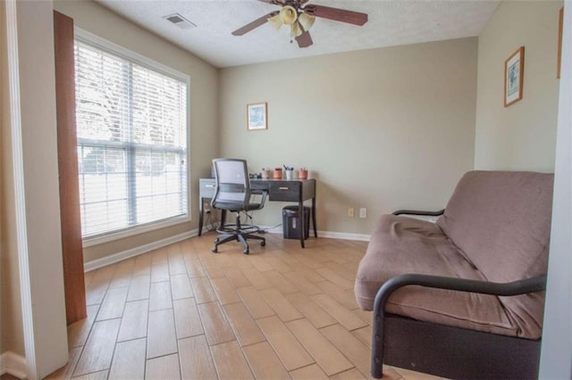 office with a textured ceiling, ceiling fan, and light hardwood / wood-style flooring