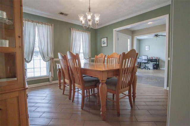 tiled dining room with ceiling fan with notable chandelier and ornamental molding