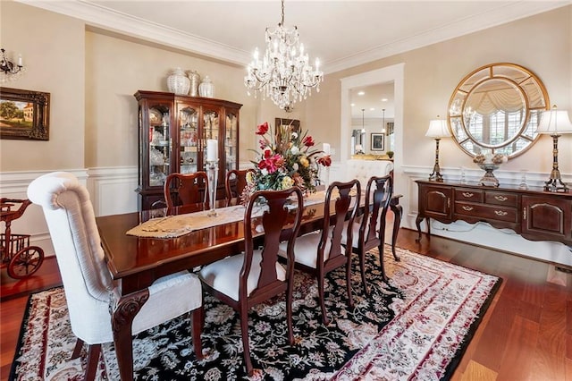 dining space with crown molding, dark hardwood / wood-style floors, and a notable chandelier