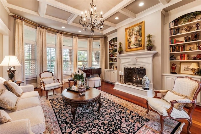 sitting room featuring coffered ceiling, built in shelves, wood-type flooring, and beamed ceiling