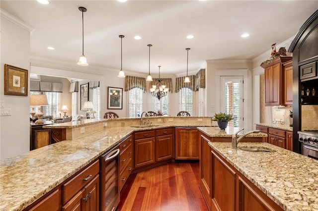 kitchen with sink, pendant lighting, wine cooler, and light stone counters