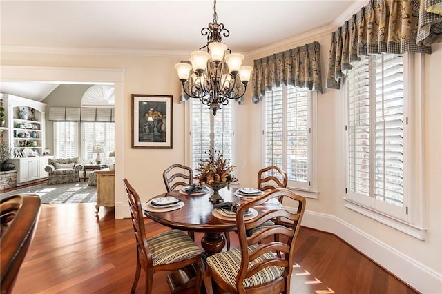 dining room with crown molding, a notable chandelier, hardwood / wood-style flooring, and plenty of natural light