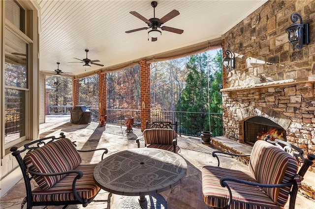 view of patio / terrace with ceiling fan and an outdoor stone fireplace