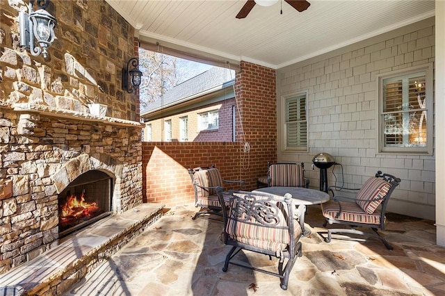 view of patio with ceiling fan and an outdoor stone fireplace