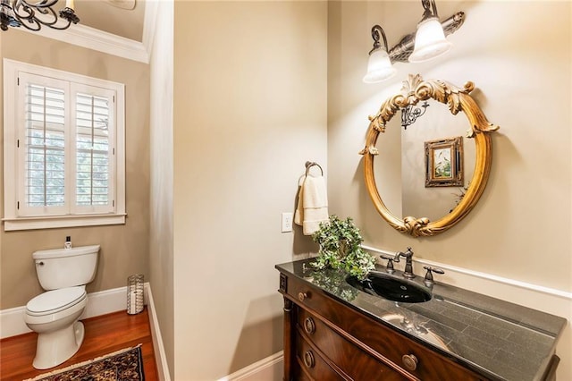 bathroom with ornamental molding, hardwood / wood-style floors, vanity, and toilet