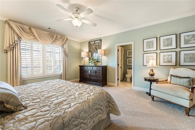 carpeted bedroom with ceiling fan, ensuite bath, and ornamental molding