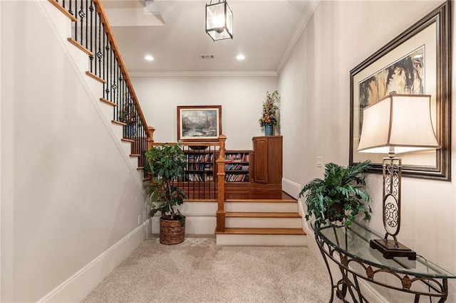 staircase with ornamental molding and carpet